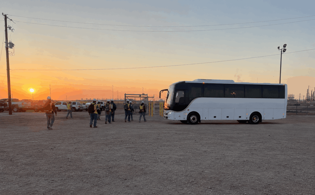 charter bus moving employees between a parking lot and a plant gate during shift change in abilene
