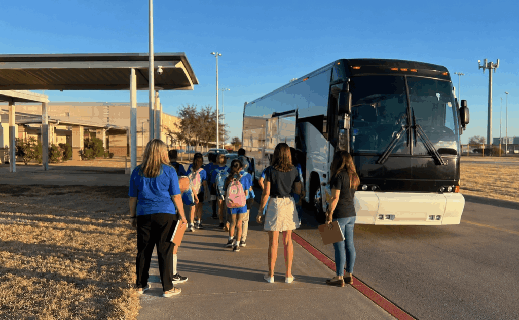 charter bus picking up students and chaperones at an abilene school for a field trip