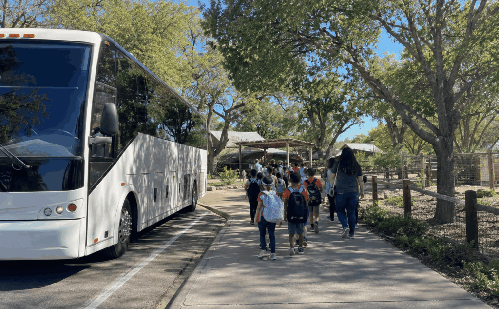 charter bus dropping off a school field trip group near the abilene zoo and nelson park area