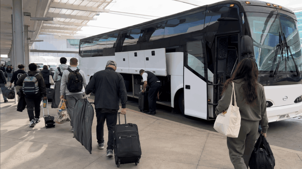 charter bus dropping off travelers at a dfw airport terminal before departure
