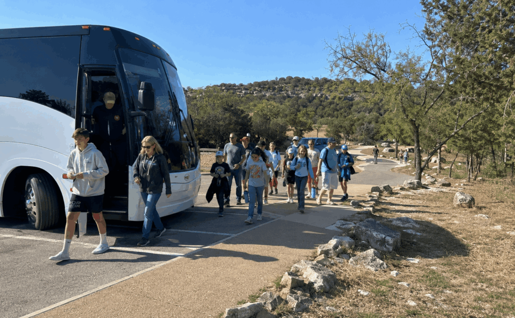 charter bus dropping off an abilene group near dinosaur valley state park for a glen rose dinosaur tracks and safari day trip