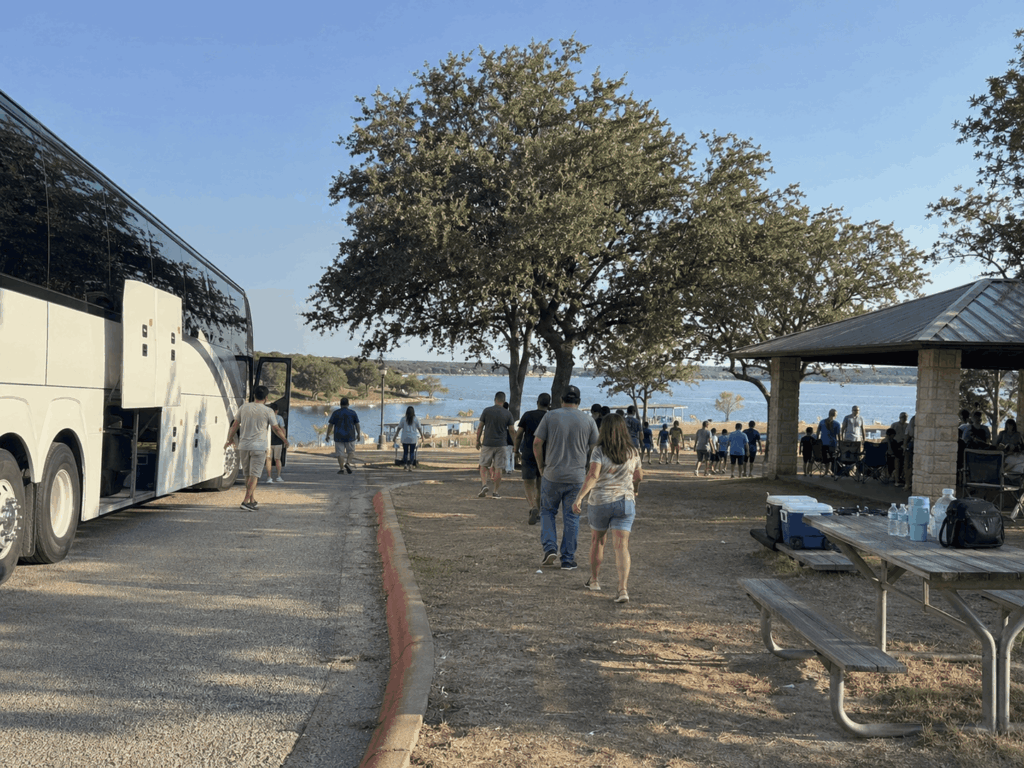 group walking back from the fishing pier and swim beach toward a charter bus at lake brownwood state park