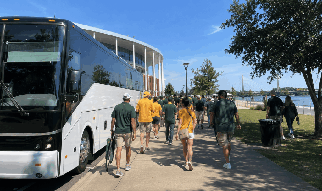 baylor football fans walking from a charter bus toward touchdown alley tailgates before kickoff
